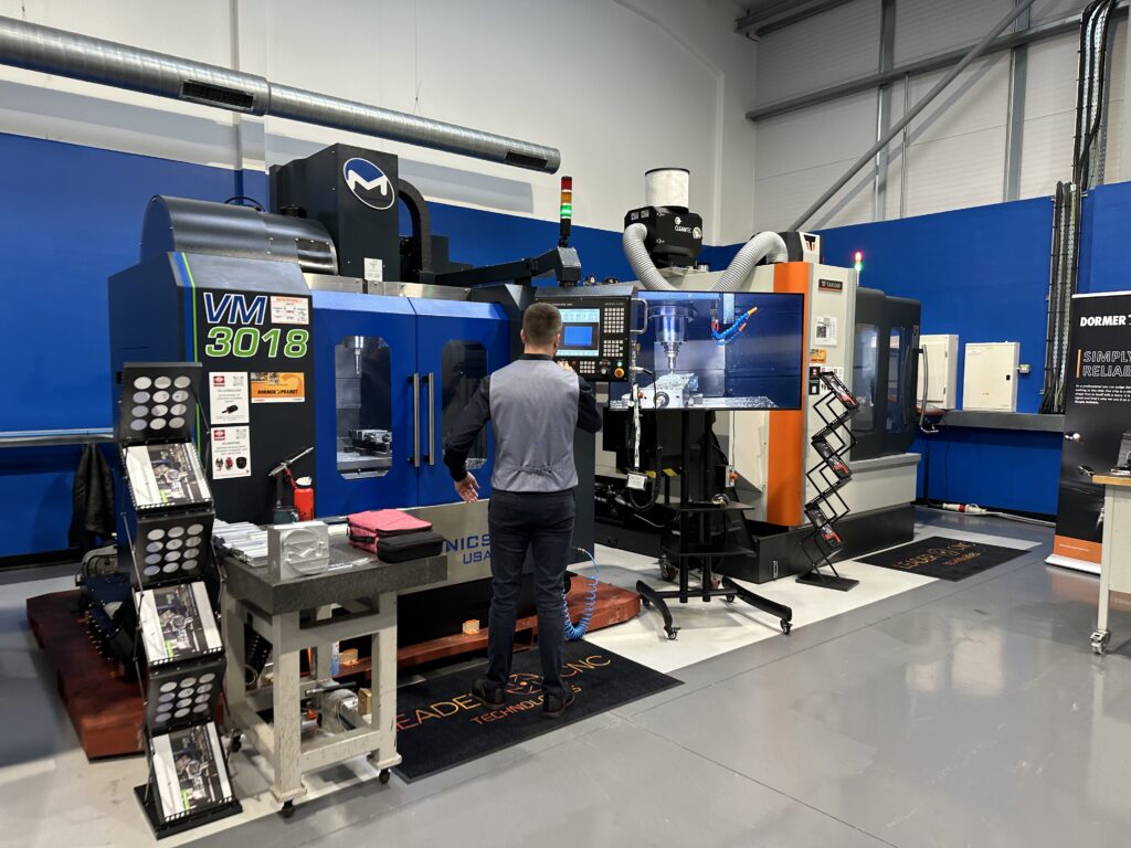 Leader CNC Technologies Showroom with two CNC machines and man on the control system of one of the machines.