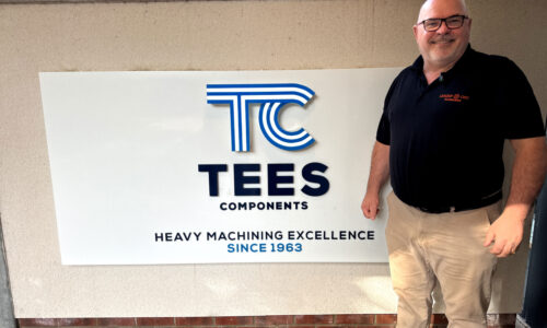 Leader CNC Technologies team member standing outside Tees Components welcome sign
